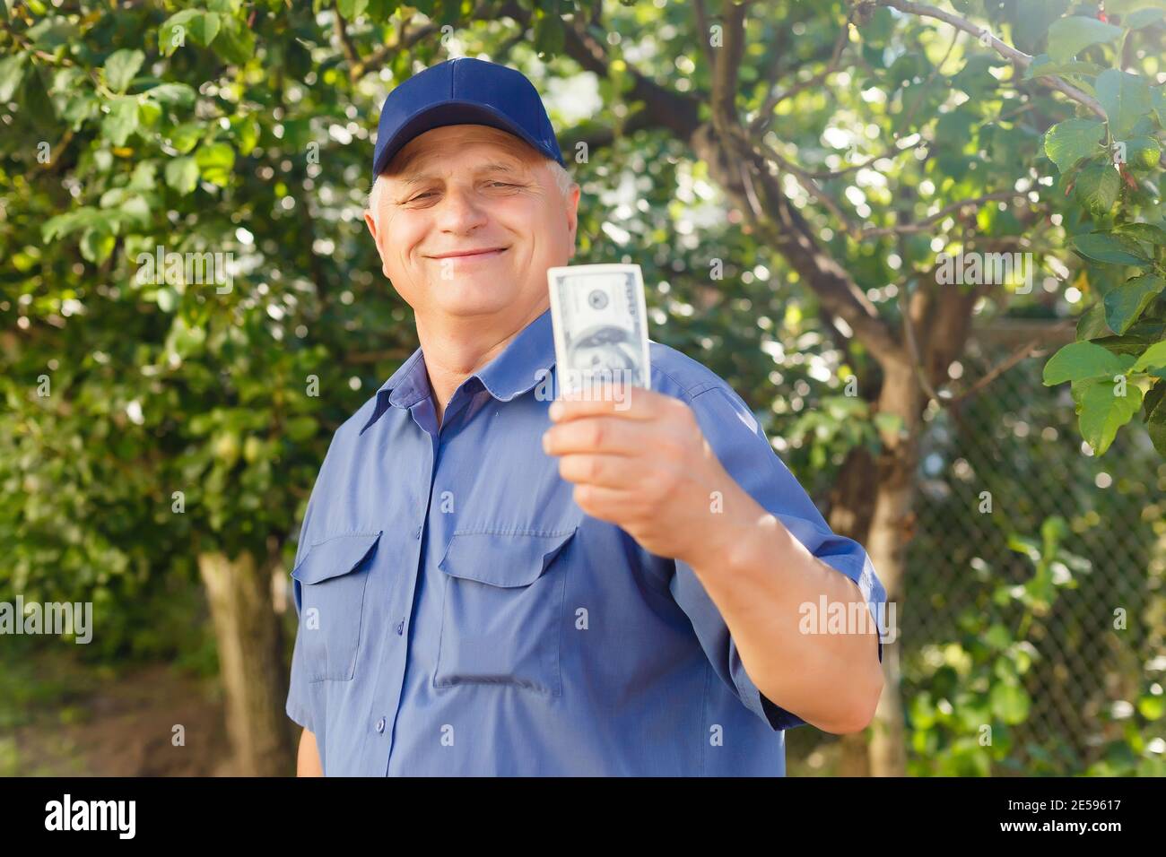Un uomo anziano che tiene una pila di soldi Foto Stock
