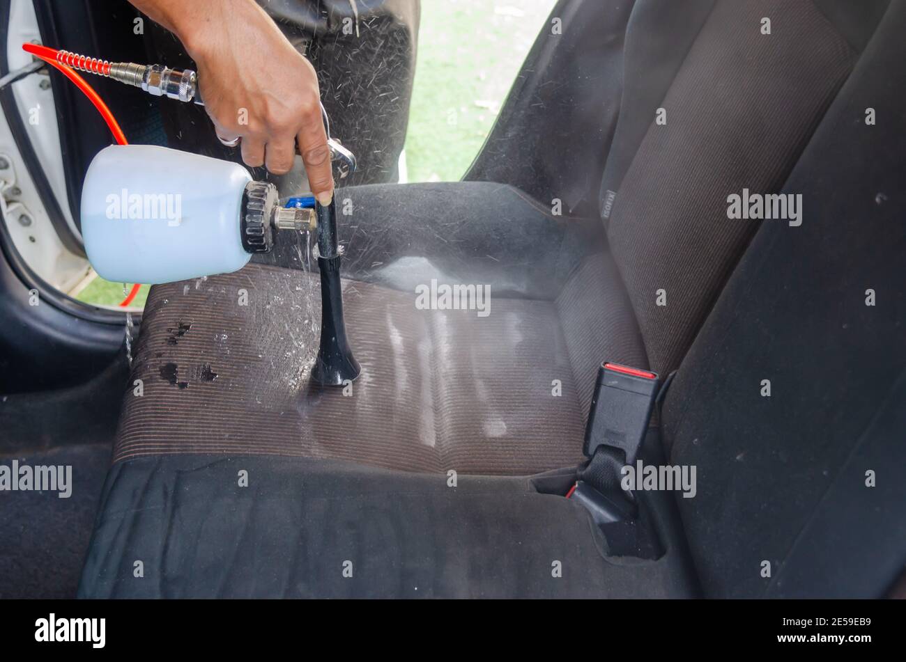 Pulire il sedile dell'auto con una macchina in auto servizio Foto Stock