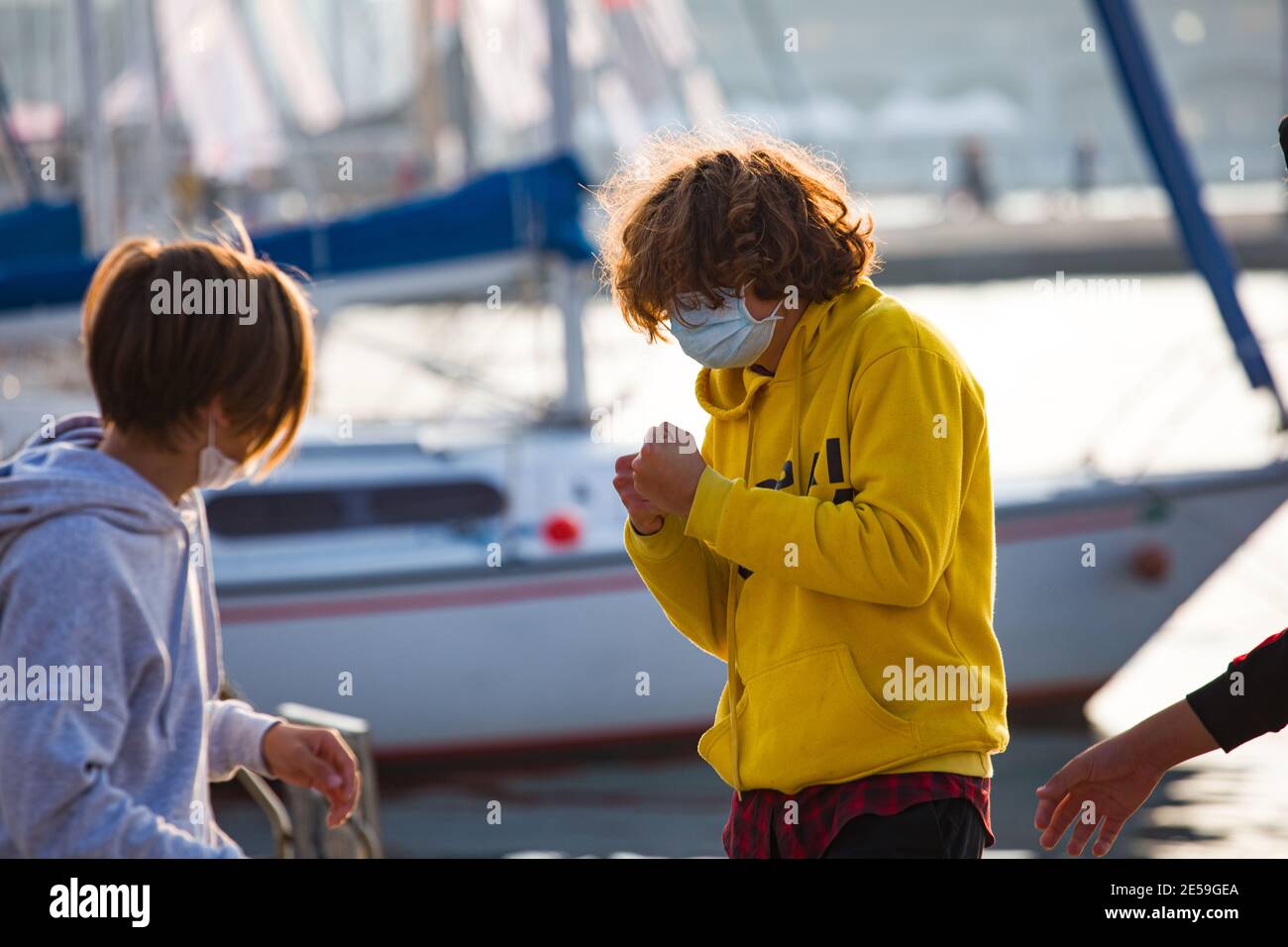Trieste, Italia - Ottobre, 10: Ragazzo con felpa gialla che gioca con un amico imitando un pugile il 10 ottobre 2020 Foto Stock