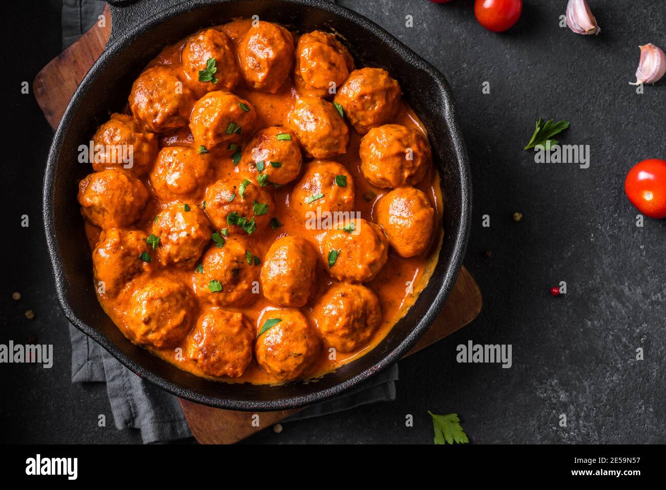 Polpette fatte in casa in salsa di pomodoro primo piano. Polpette di manzo in teglia di ghisa su sfondo nero. Foto Stock