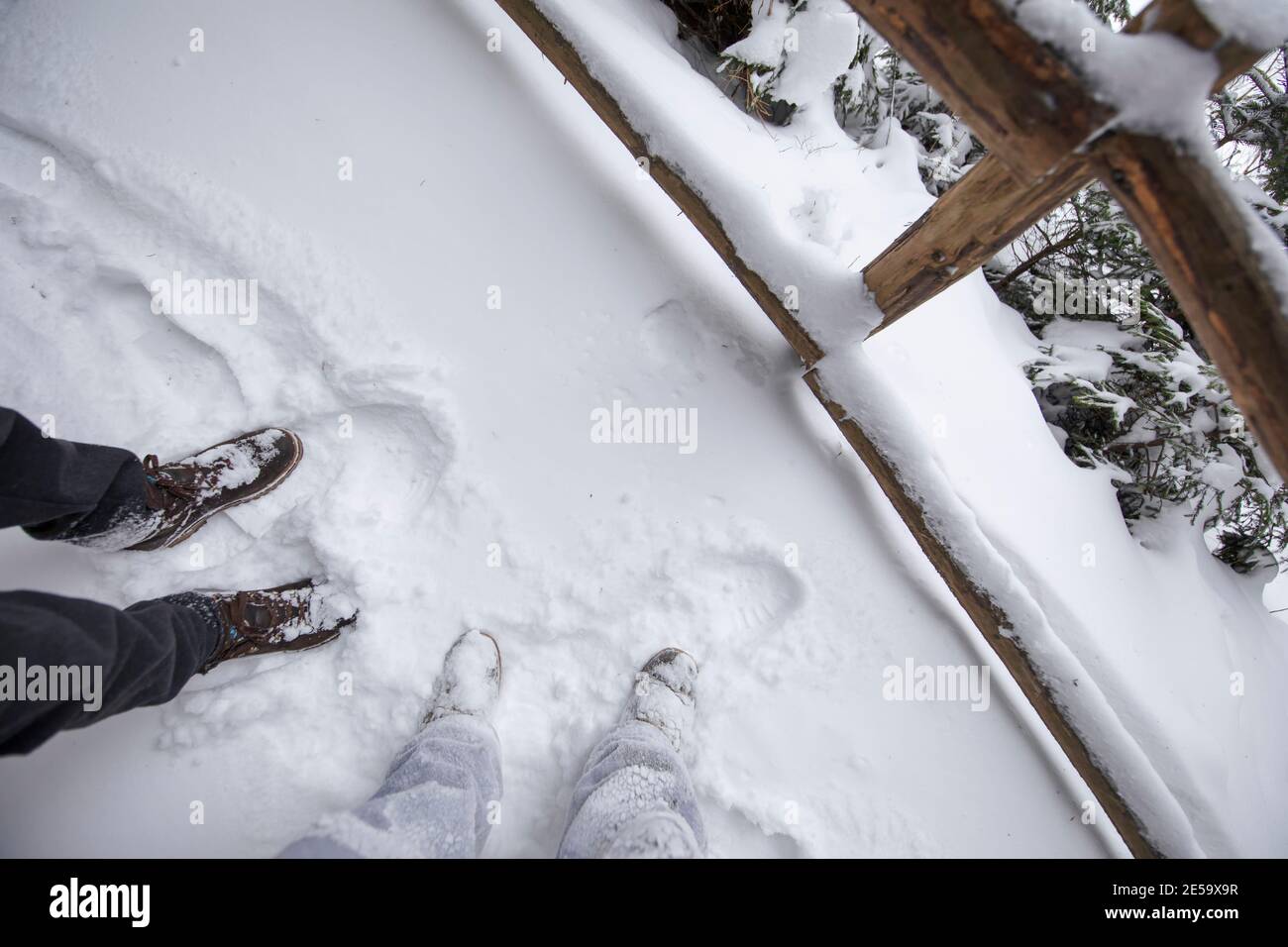 Gambe di due persone nella neve, scarpe in un percorso innevato. Foto Stock