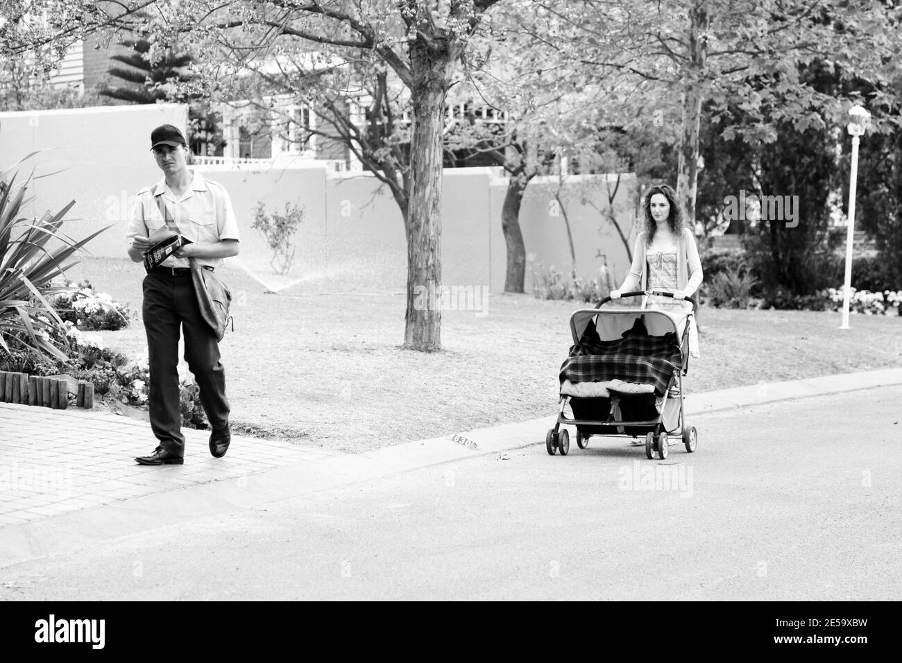 JOHANNESBURG, SUDAFRICA - 05 gennaio 2021: Johannesburg, Sudafrica - 11 settembre 2010: Mamma con pram e Mailman che consegnano la posta in un sub ricco Foto Stock