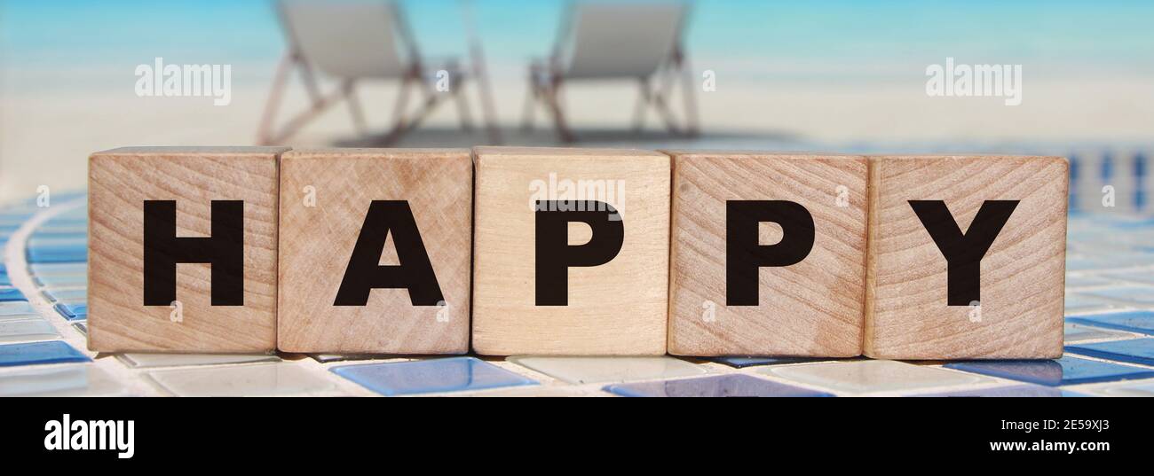 Happy parola cubetti di legno su sfondo oceano. Concetto di stile di vita Foto Stock