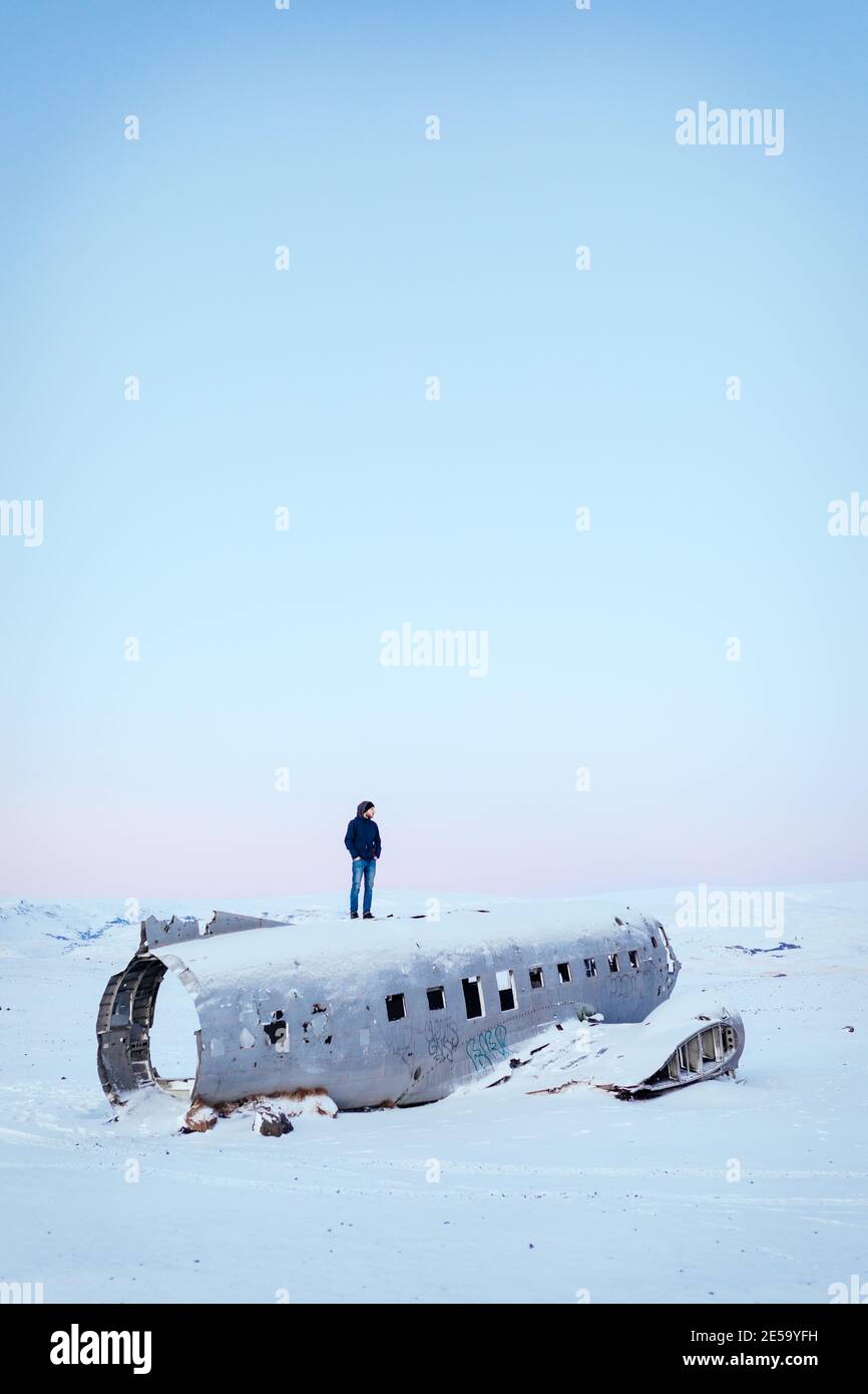 Uomo in piedi da solo su un relitto aereo a Solheimasandur, Islanda Foto Stock