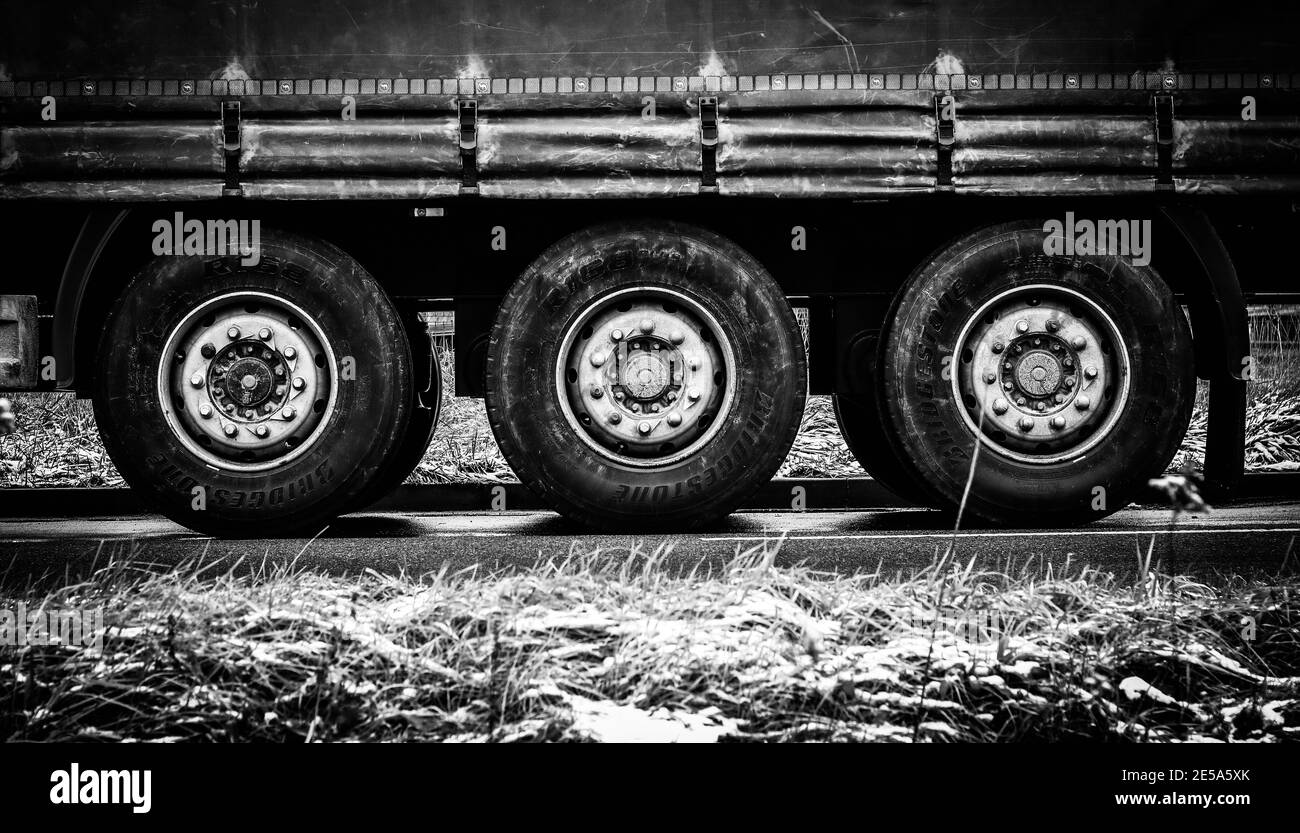 Immagine simmetrica di tre assi con ruote di semirimorchio inclinabile, immagine in bianco e nero Foto Stock