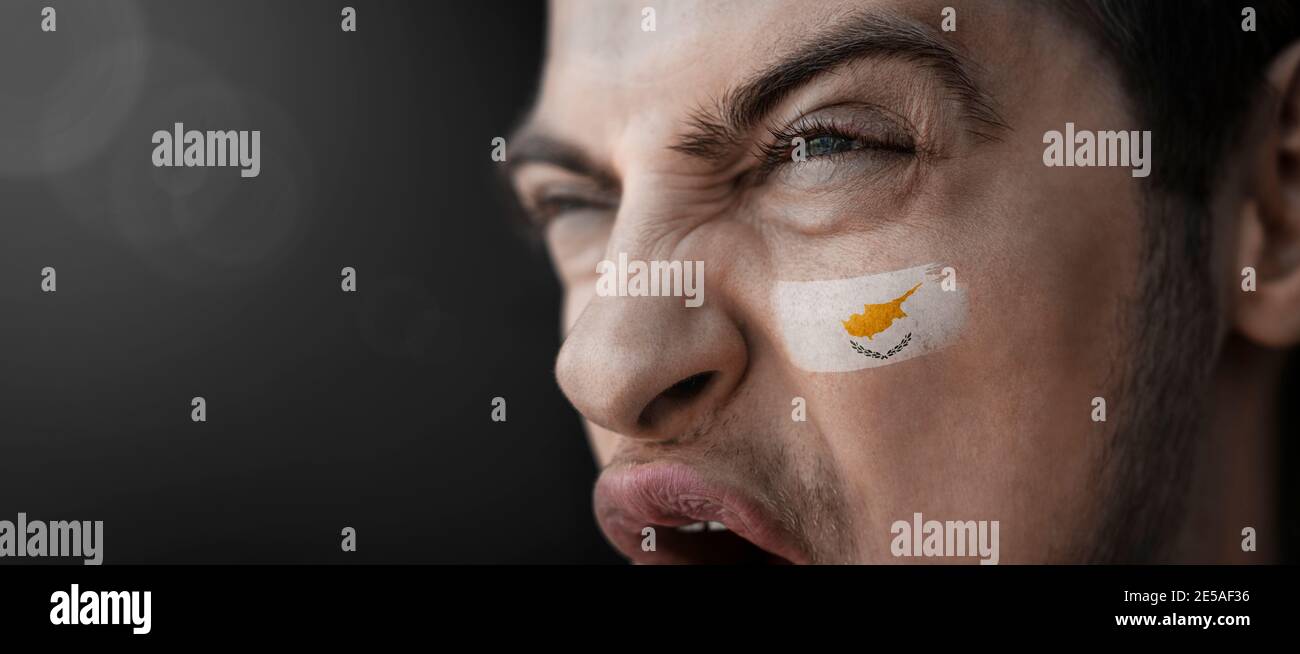 Un uomo urlante con l'immagine del cittadino cipriota bandiera sul viso Foto Stock