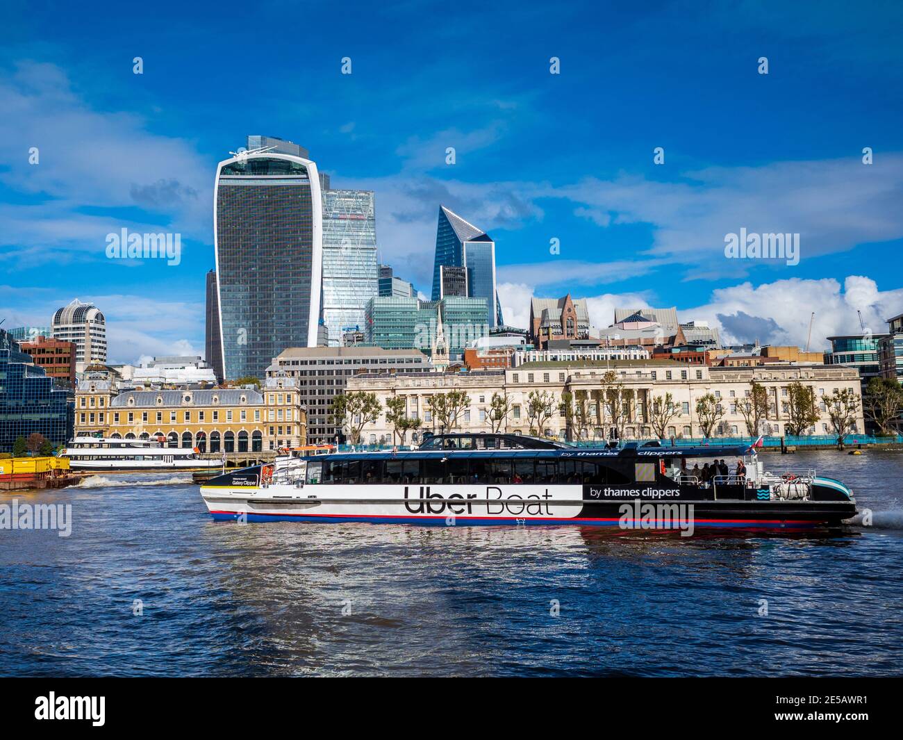UBER Boat di Thames Clipper. Vista sul fiume della città di Londra. Il River Bus di marca UBER passa davanti all'edificio Walkie Talkie e al quartiere finanziario della City of London Foto Stock