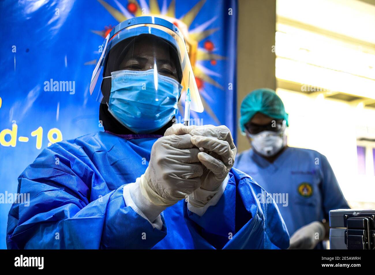 Medan, Indonesia. 19 gennaio 2021. Un operatore sanitario un tuta protettiva che indossa contiene una siringa con vaccino Sinovac da somministrare agli operatori sanitari di prima linea all'ospedale RS Adam Malik di Medan. Credit: SOPA Images Limited/Alamy Live News Foto Stock