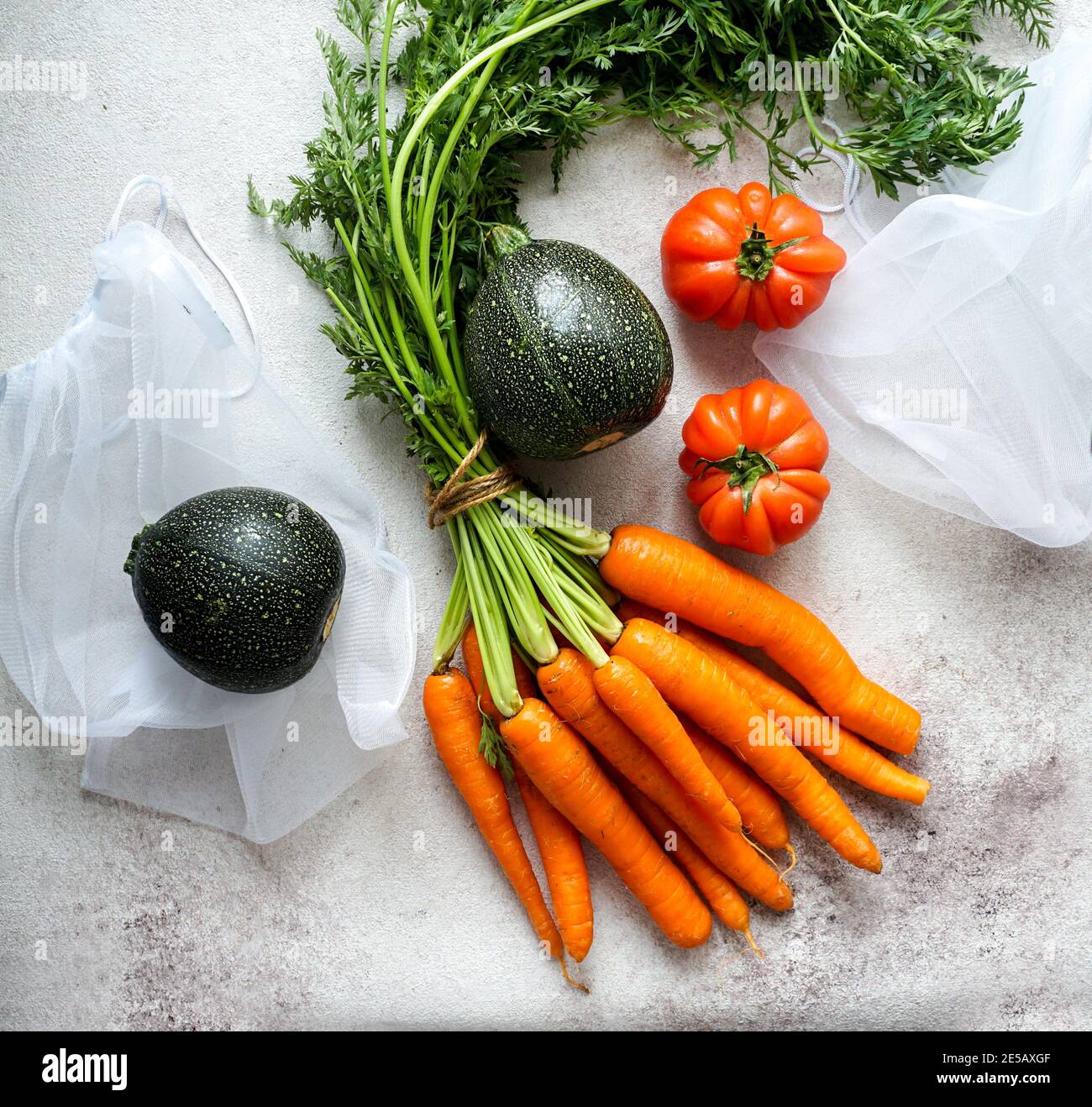 Custodia per alimenti zero Waste Eco Bag con carote, pomodori, vista dall'alto, sacchetti ecofriendly per verdure, imballaggio ecologico Foto Stock