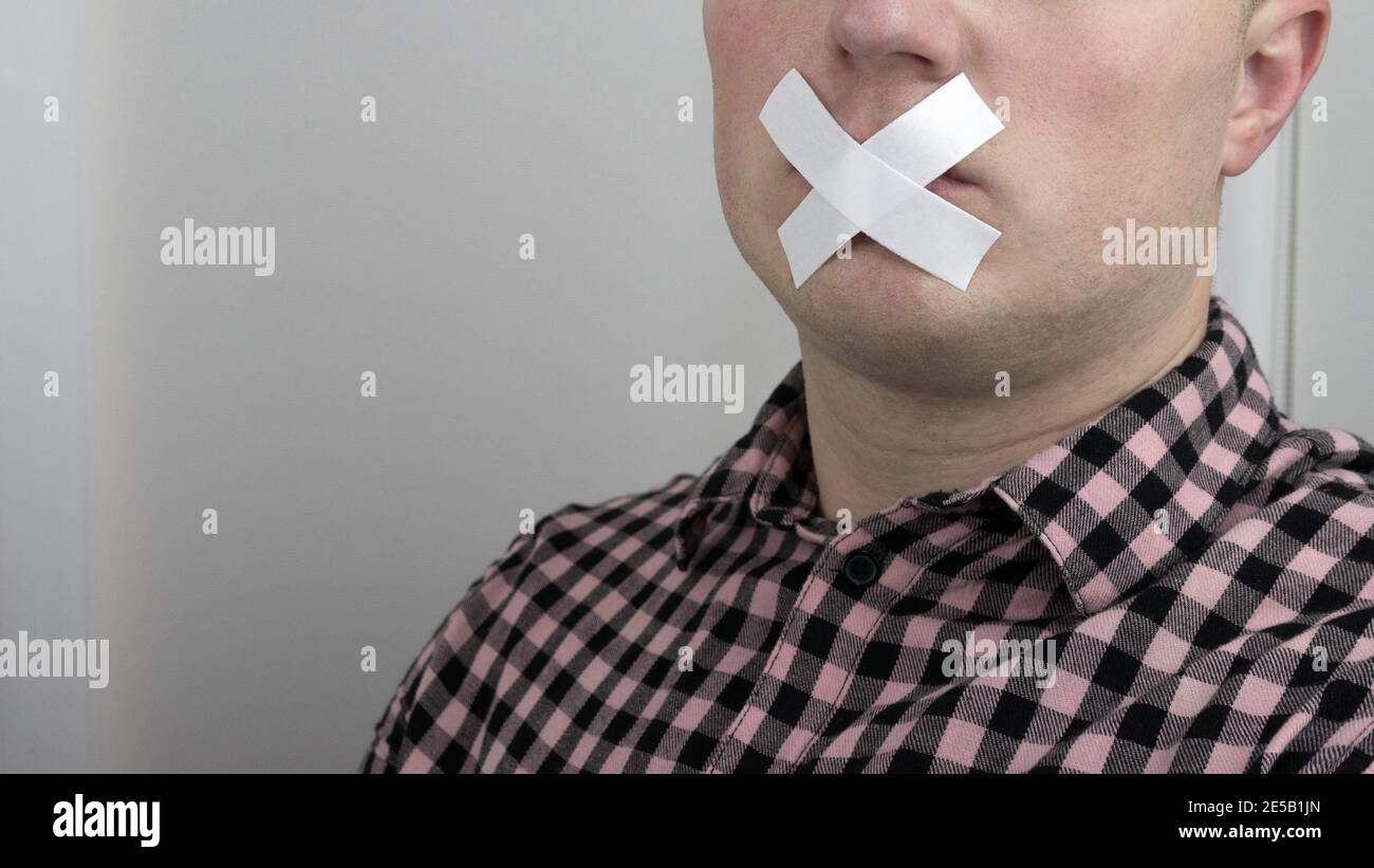 Un uomo a bocca chiusa con nastro a condotto, un uomo con nastro adesivo sulle labbra, un uomo a bocca chiusa. Foto Stock