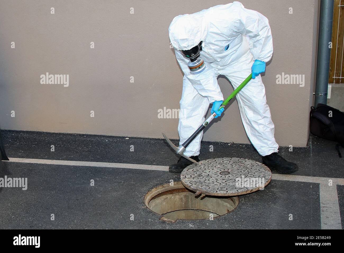 Marsiglia, Francia. 26 gennaio 2021. Un operatore sanitario che indossa una tuta per dispositivi di protezione individuale (DPI) take the cover off a manhole per l'ispezione a Marsiglia. L'unità COMETE (Covid Marseille Environmental Testing Expertise) raccoglie campioni di acque reflue in vari punti della città per determinare i quartieri, le scuole o alcuni edifici contaminati da Covid-19 attraverso il test di questi campioni. Credit: SOPA Images Limited/Alamy Live News Foto Stock