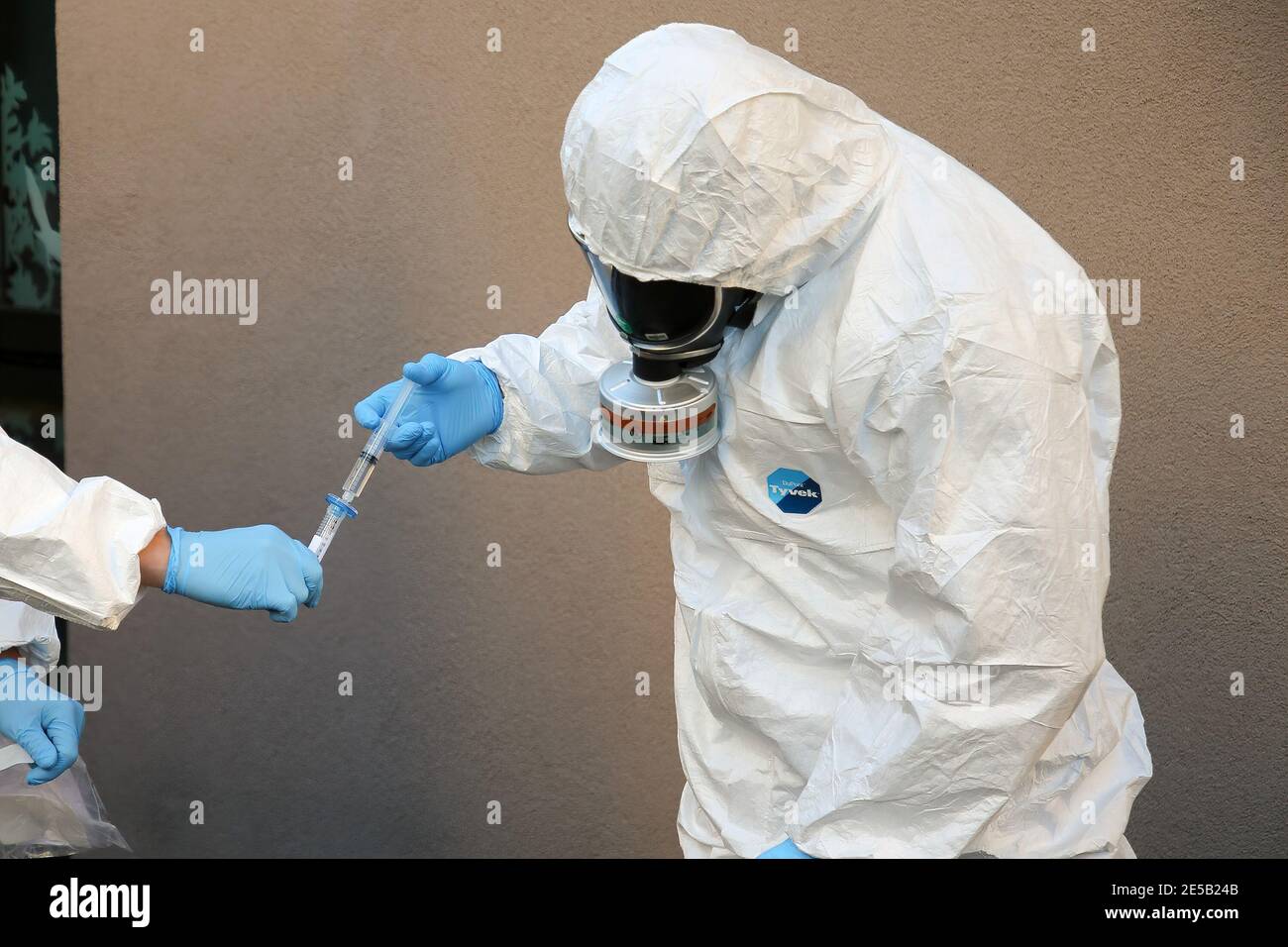 Marsiglia, Francia. 26 gennaio 2021. Gli operatori sanitari che indossano tute di protezione individuale (DPI) prelevano un campione dall'uscita fognaria di una casa di riposo durante l'analisi delle acque reflue. L'unità COMETE (Covid Marseille Environmental Testing Expertise) raccoglie campioni di acque reflue in vari punti della città per determinare i quartieri, le scuole o alcuni edifici contaminati da Covid-19 attraverso il test di questi campioni. Credit: SOPA Images Limited/Alamy Live News Foto Stock