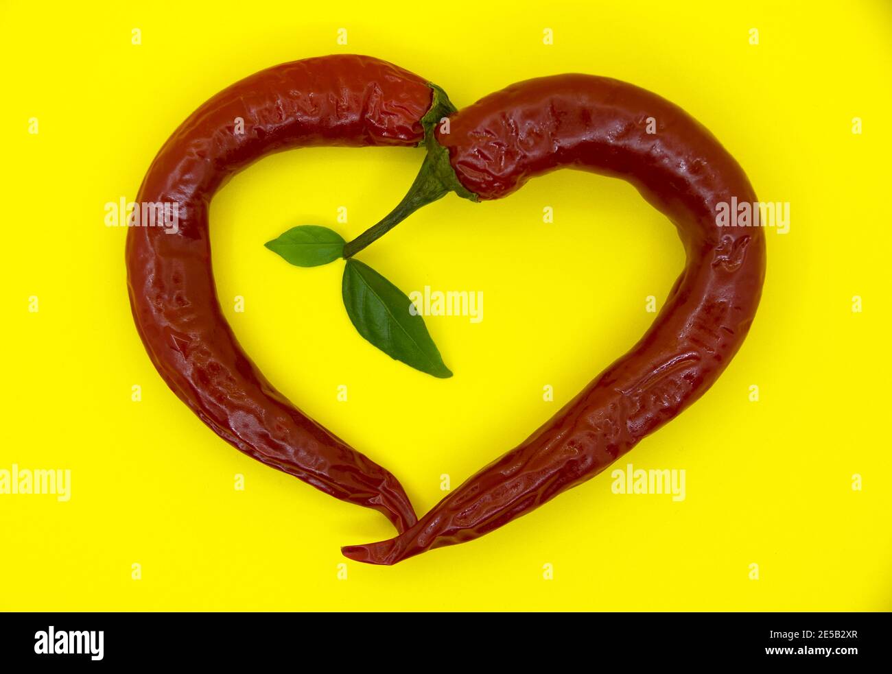 Cuore caldo di peperone rosso su sfondo giallo. Foto Stock