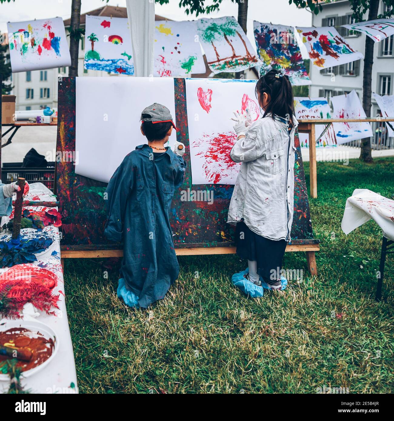 Due bambini dipingendo a bordo all'aperto nel parco. Attività in natura. Felice infanzia e creatività. Famiglia e insieme. Foto Stock