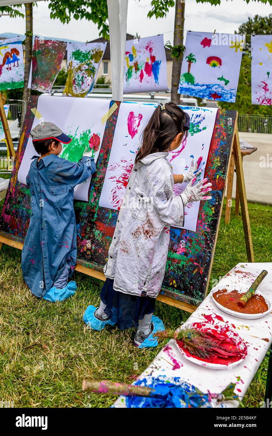Due bambini dipingendo a bordo all'aperto nel parco. Attività in natura. Felice infanzia e creatività. Famiglia e insieme. Foto Stock
