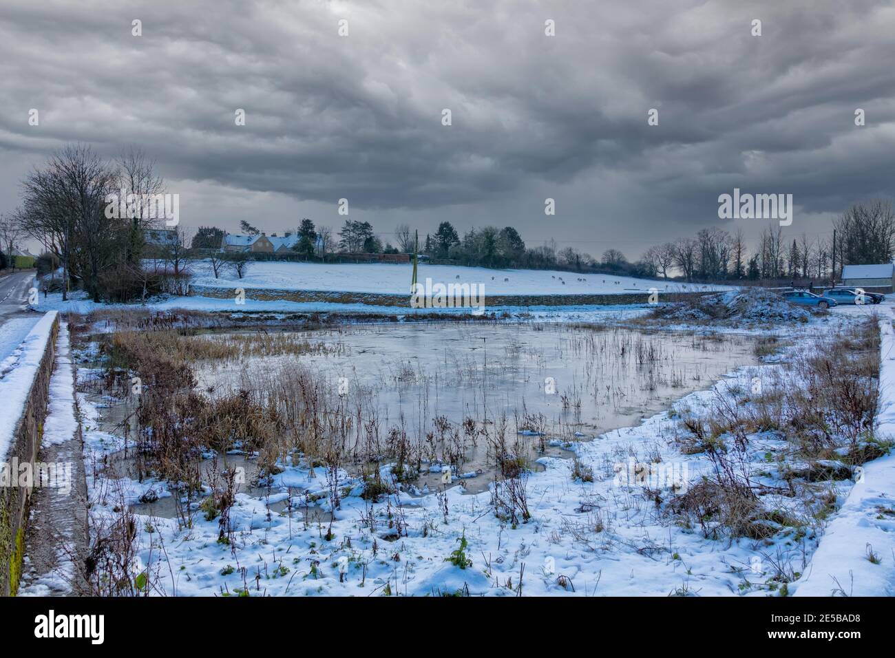 Frozen villaggio stagno nell'inverno del 2021, Hawkesbury Upton, il Cotswolds, Gloucestershire, Inghilterra, Regno Unito Foto Stock
