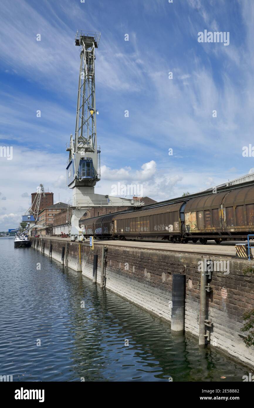 Karlsruhe, Germania: Porto di Karlsruhe con carri merci, ferrovia, gru, fiume reno e edifici di stoccaggio Foto Stock