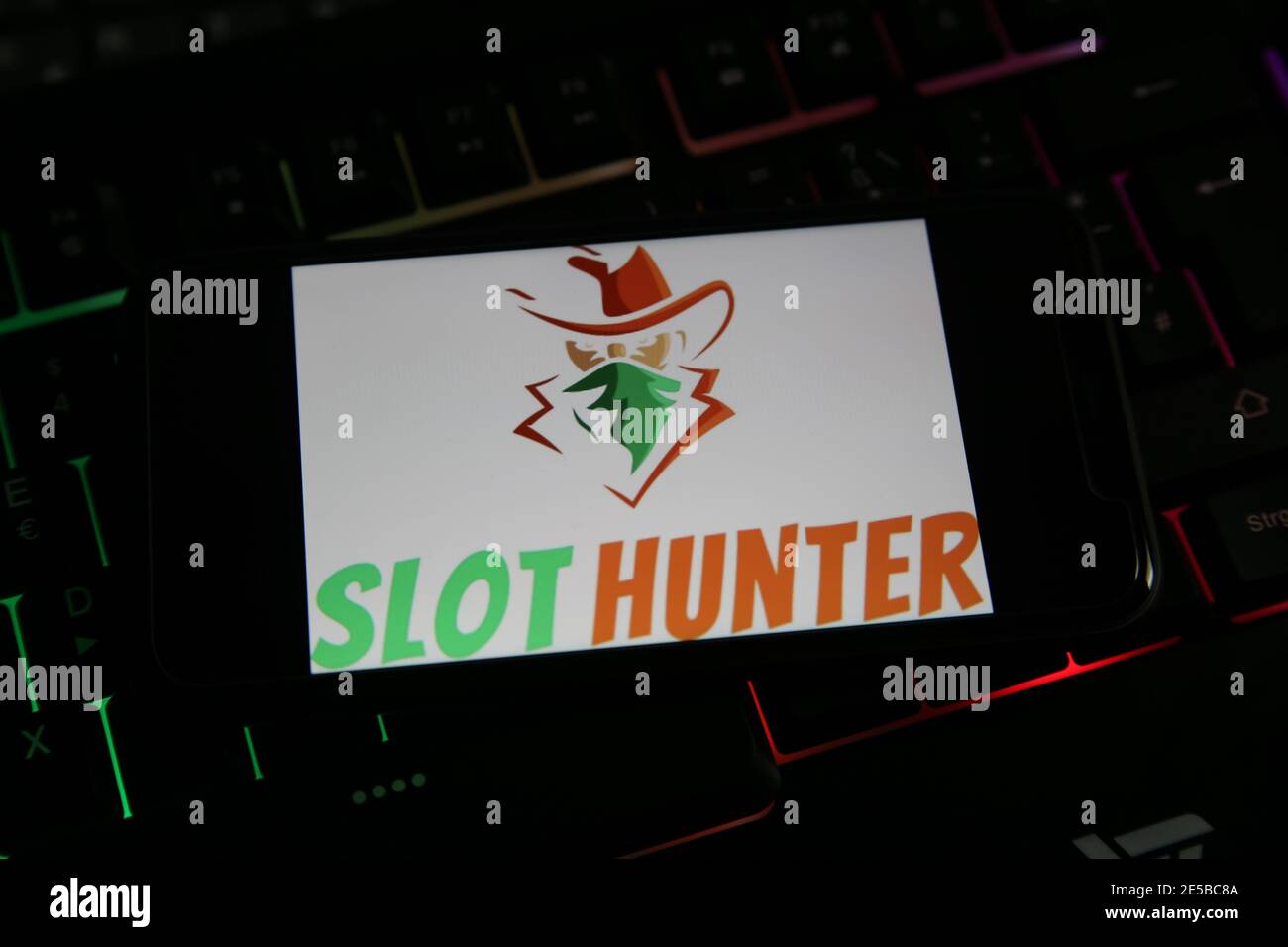 Viersen, Germania - 9 gennaio. 2021: Closeup dello schermo dello smartphone con la scritta del logo del giocatore online slot Hunter sulla tastiera illuminata (fo Foto Stock