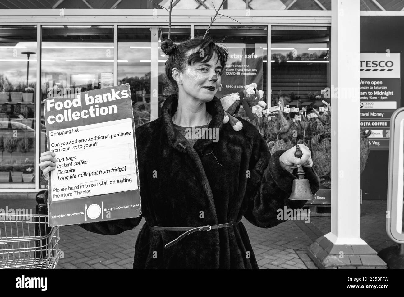 Una donna locale in abito di fantasia che raccoglie per UNA banca di cibo, Lewes, Sussex orientale, Regno Unito. Foto Stock