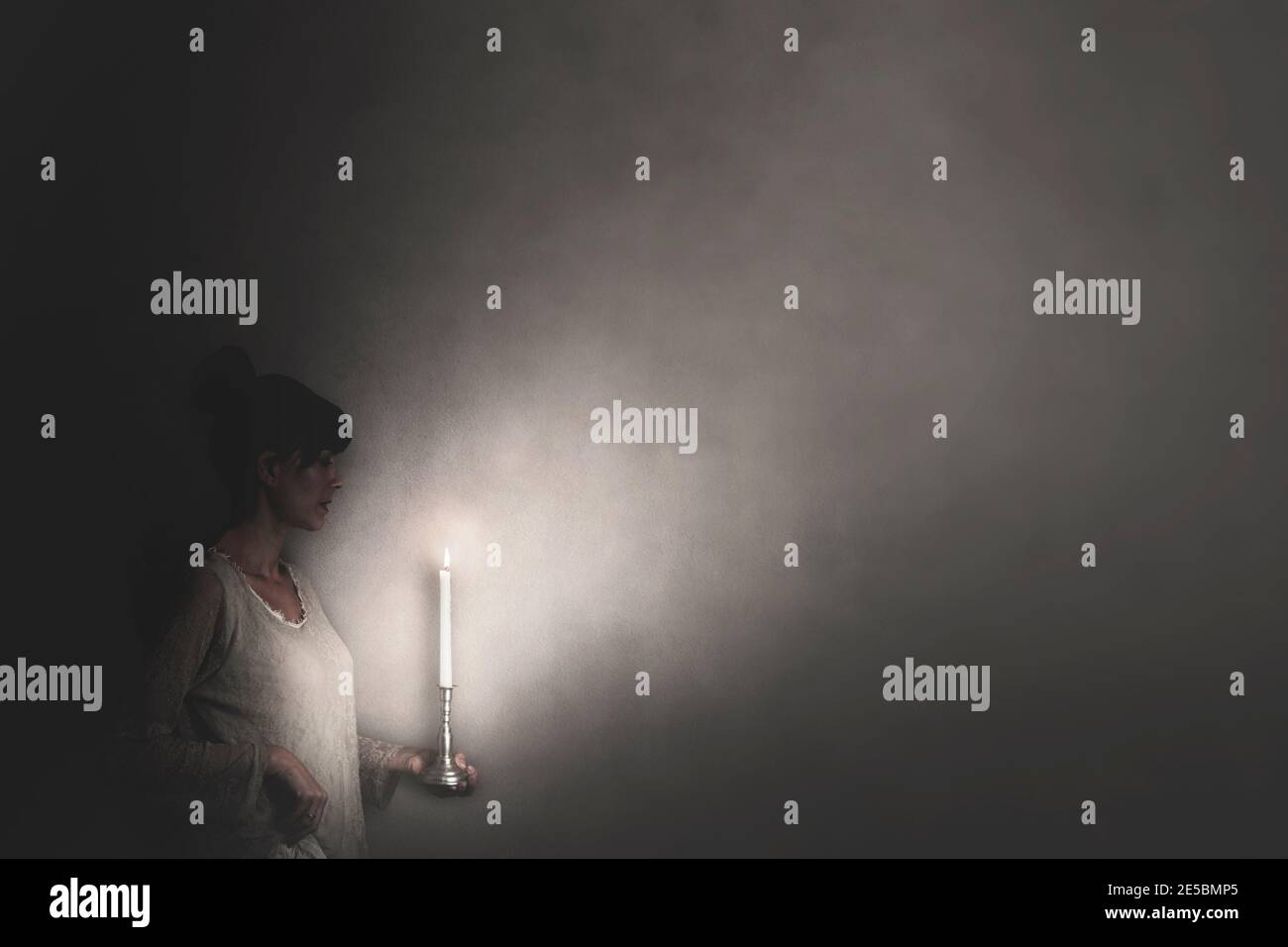 donna accende la strada con una candela, speranza concetto Foto Stock