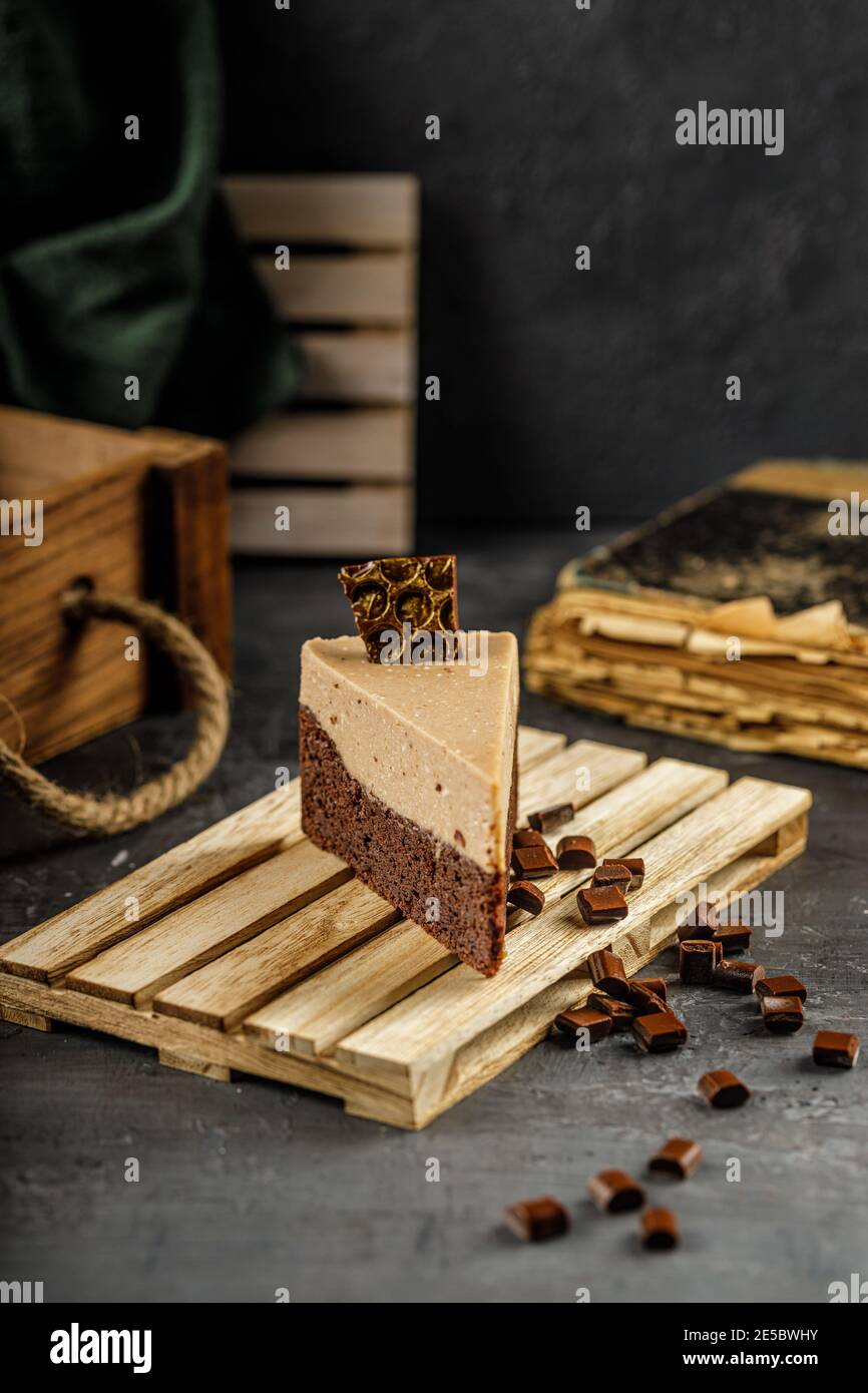 Ancora vita di torta di castagne con mousse di cioccolato su un tavolo grigio scuro con pezzi di cioccolato. Foto Stock