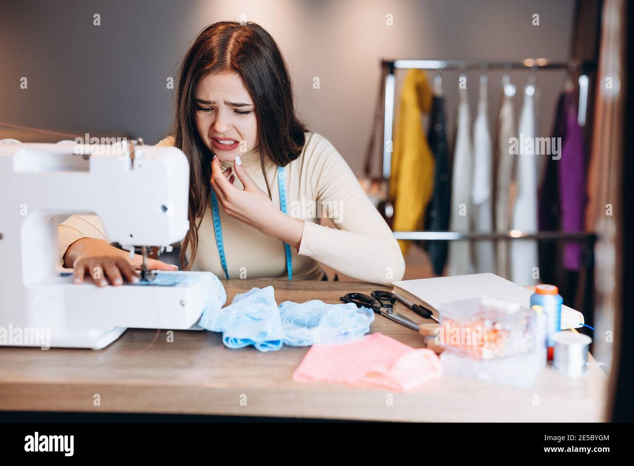 Giovane donna dressmaker cucire i vestiti sulla macchina da cucire. Fare  errori o qualcosa è andato seamstress sbagliato in officina. Creazione di abbigliamento  online design Foto stock - Alamy