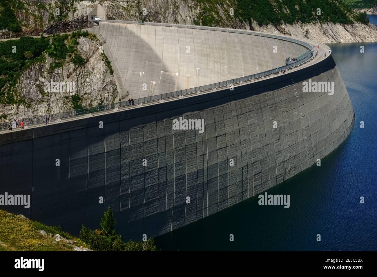 centrale idroelettrica con una diga enorme e poca gente su di esso in austria Foto Stock