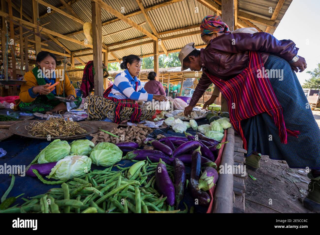 Donne che vendono verdure fresche sul mercato di strada in villaggio, lago Foto Stock