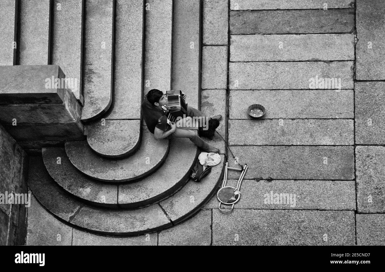 Vista dall'alto su un musicista di strada seduto sul scale Foto Stock