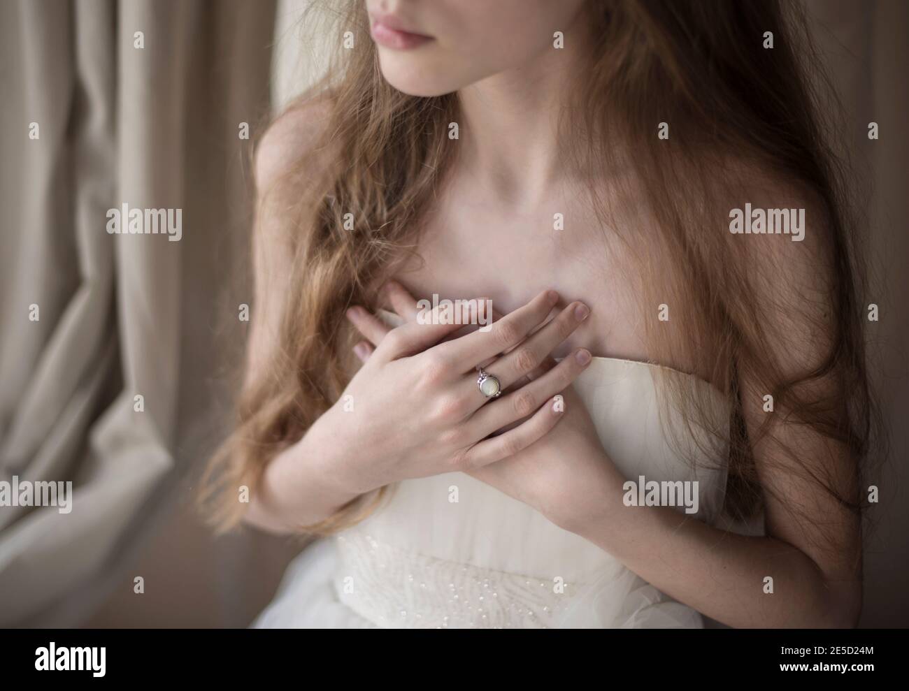 Ritratto di una ragazza con le mani ripiegate su di lei torace Foto Stock