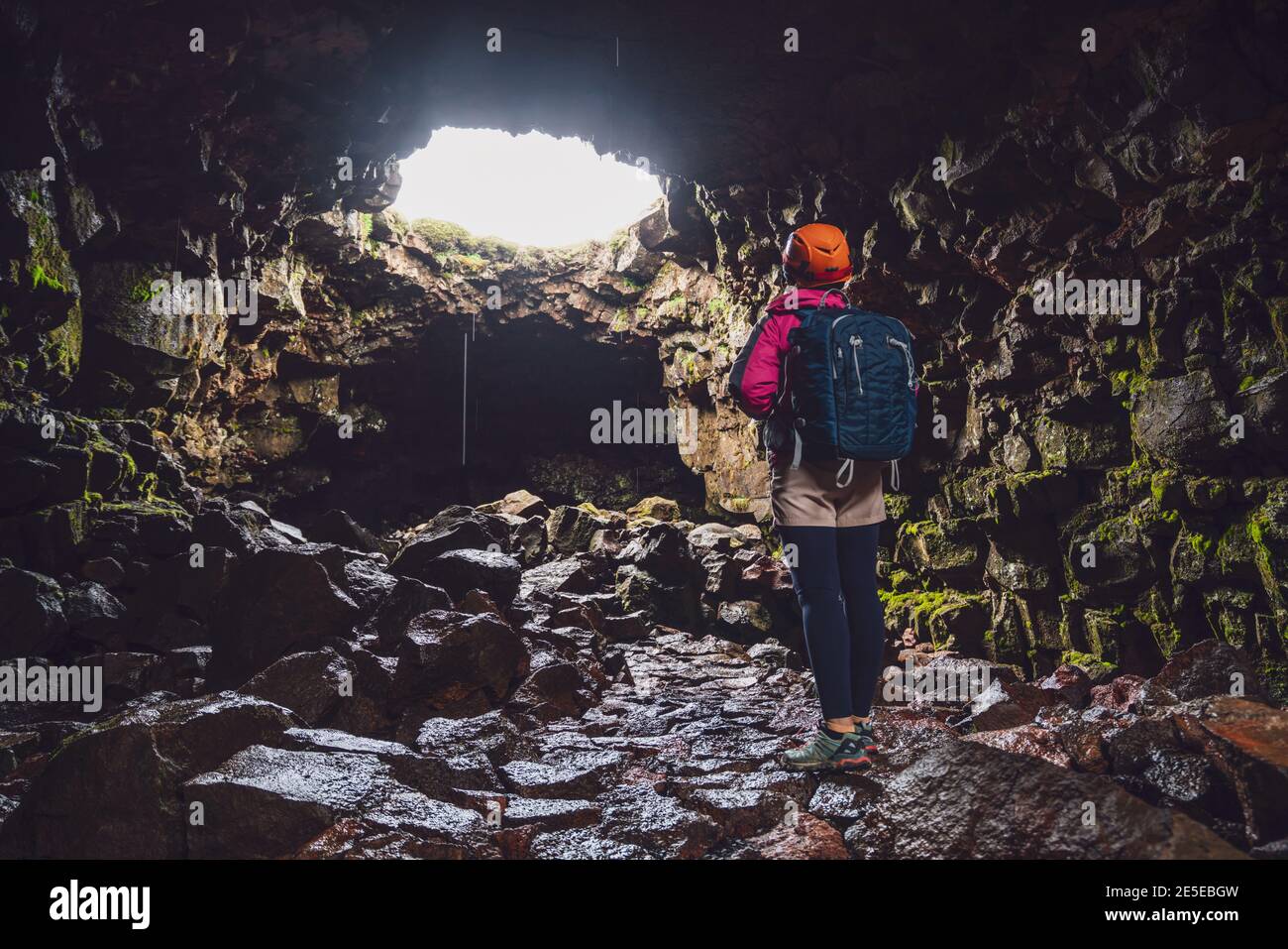 Donna viaggiatore esplorare il tunnel di lava in Islanda. Raufarholshellir è un bellissimo mondo nascosto di grotta. È una delle lava più lunghe e conosciute Foto Stock