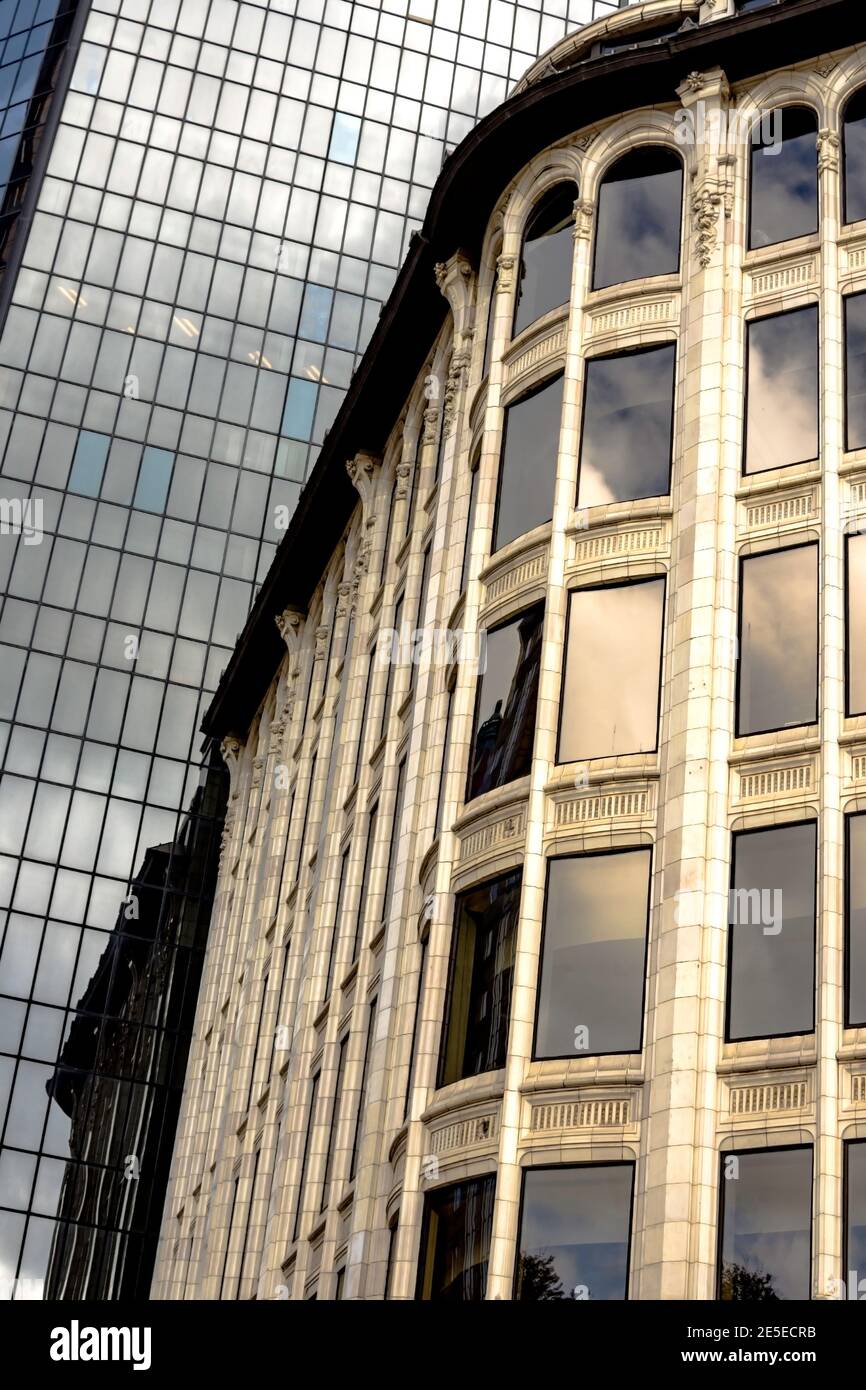 Primo piano con dettagli architettonici unici nell'edificio storico con una torre moderna sullo sfondo Foto Stock