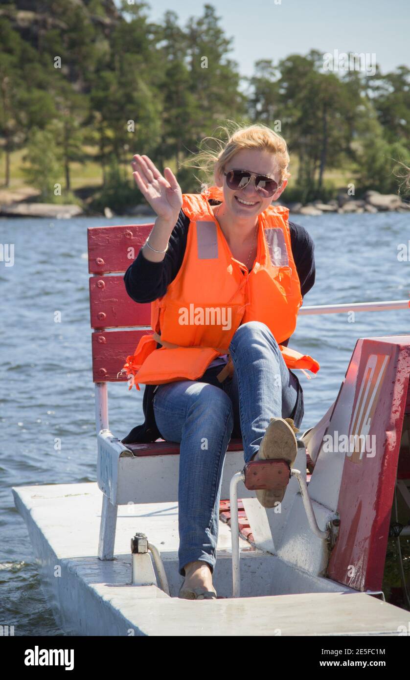 Una ragazza che indossa un giubbotto salvagente durante una gita in barca. Foto Stock