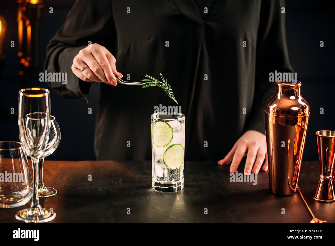 Donna che fa fresco gin tonic cocktail con lime Foto stock - Alamy