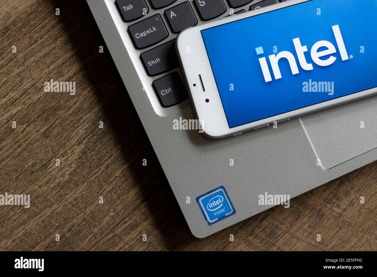 Il nuovo logo Intel è visibile su uno smartphone con un notebook con etichetta Intel-Inside in background il 25 gennaio 2021. Foto Stock