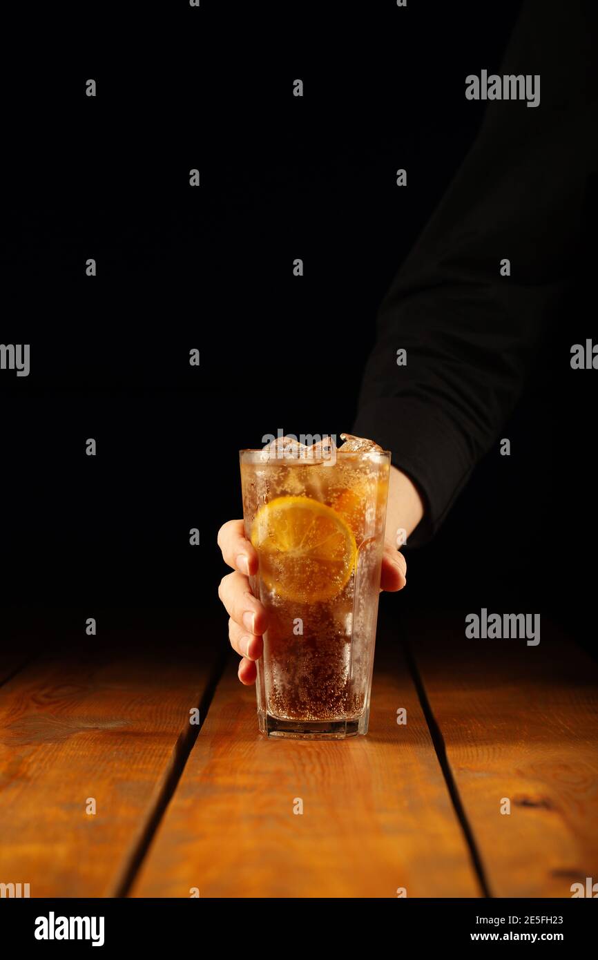 Bicchiere di tè lungo sull'isola per tenere a mano il ghiaccio Foto Stock