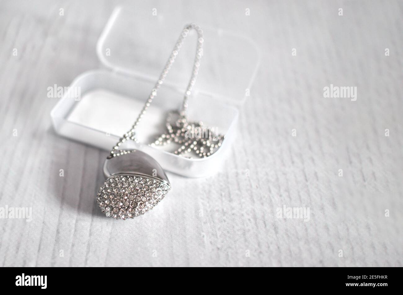 Cuore con pietre come Swarovski su una catena. Portachiavi, sfocatura. Foto Stock