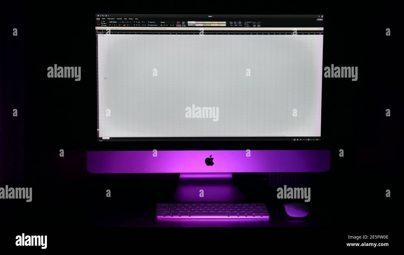Primo piano sullo schermo del computer di Apple iMac su sfondo nero isolato con retroilluminazione rosa. Foglio di calcolo Excel Foto Stock