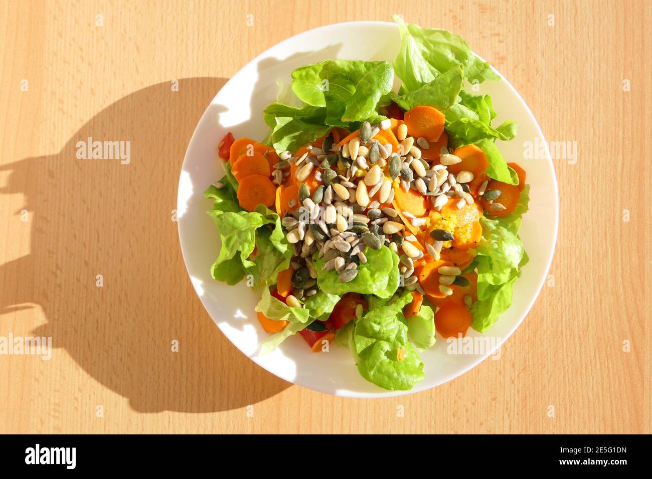 Insalata mista sana ricca di vitamine e a basso contenuto di calorie con carote, pinoli e semi di zucca Foto Stock