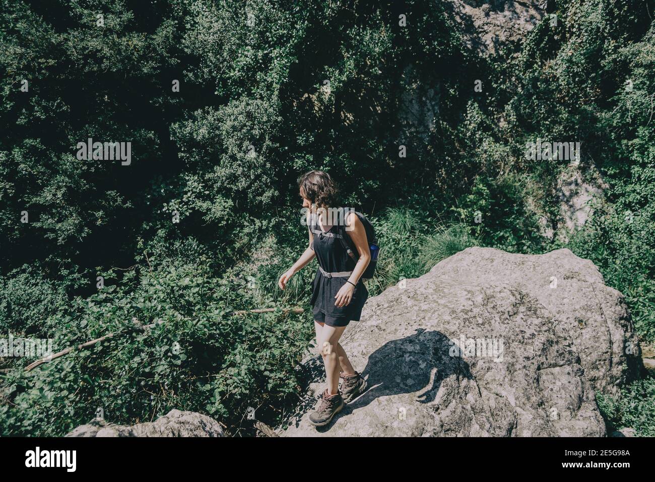 Ragazza che cammina lungo un piccolo sentiero nella montagna di Prades, Tarragona, Spagna. In una soleggiata giornata estiva Foto Stock