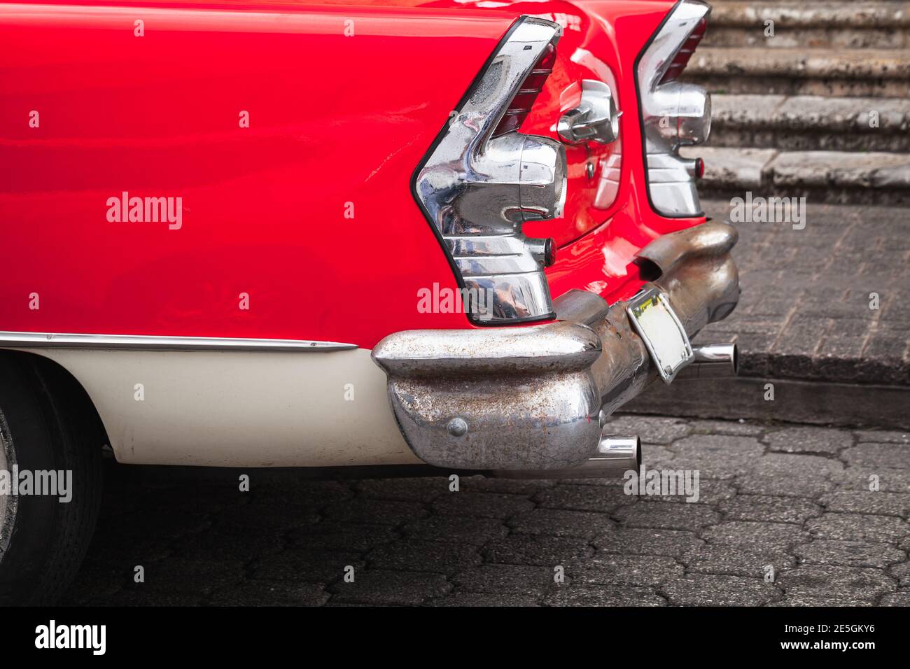 Rosso bianco oldtimer. Frammento di auto d'epoca. Luci posteriori e paraurti cromati Foto Stock