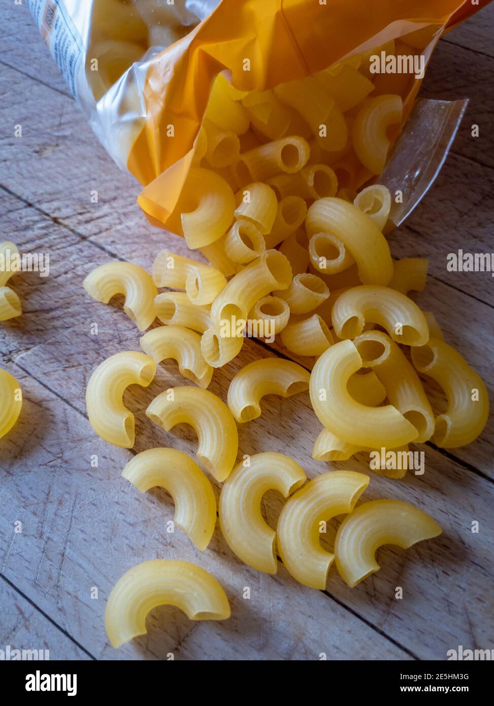 Un pacchetto aperto di maccheroni su tavola di legno. Foto Stock