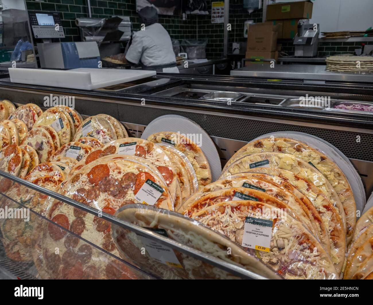 Un'esposizione di pizze appena fatte in un supermercato. Foto Stock