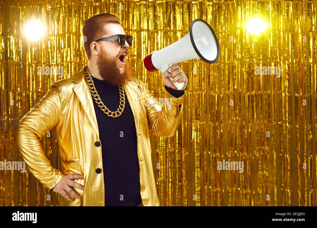 Uomo in giacca d'oro gridando in megafono, annunciando l'inizio della vendita di festa o del film casting Foto Stock