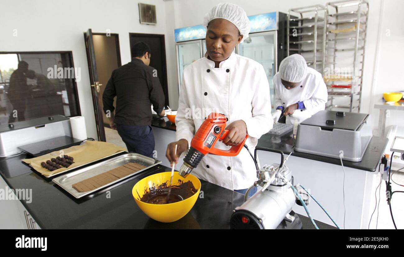 Un lavoratore artigianale riscalda il cioccolato alla temperatura corretta prima di modellare all'interno della fabbrica di cioccolato assoluto nella capitale del Kenya Nairobi 20 marzo 2015. Il consumo di cioccolato nell'Africa subsahariana è in aumento. Secondo la società di ricerche di mercato Nielsen, le vendite in Sud Africa, il mercato più grande del continente, sono salite a 6.4 miliardi di rand (531 milioni di dollari) nel 2014 rispetto ai 5.8 miliardi di rand del 2013. In Kenya, Naheed Ahmed ha iniziato Absolute Chocolate a novembre dopo aver ottenuto il suo primo assaggio di cioccolato alla scuola culinaria in Sud Africa. Ora fa 100 chilogrammi un il mese, vendendo il suo chili- Foto Stock