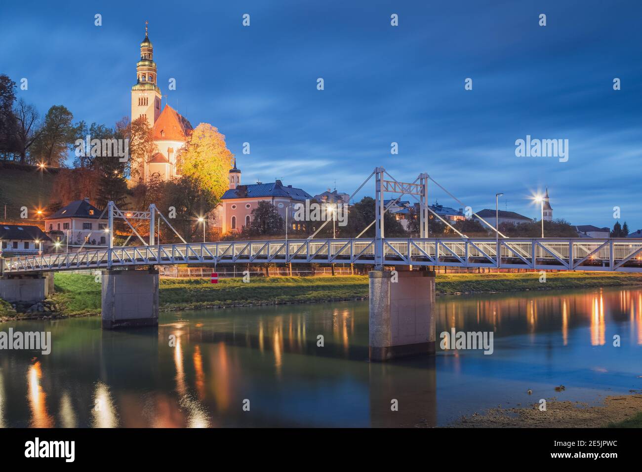 Vista serale della città lungo il fiume Salzach a Salisburgo, l'Austria del Mullner Steg Bridge e la chiesa di Pfarre Mulln Foto Stock