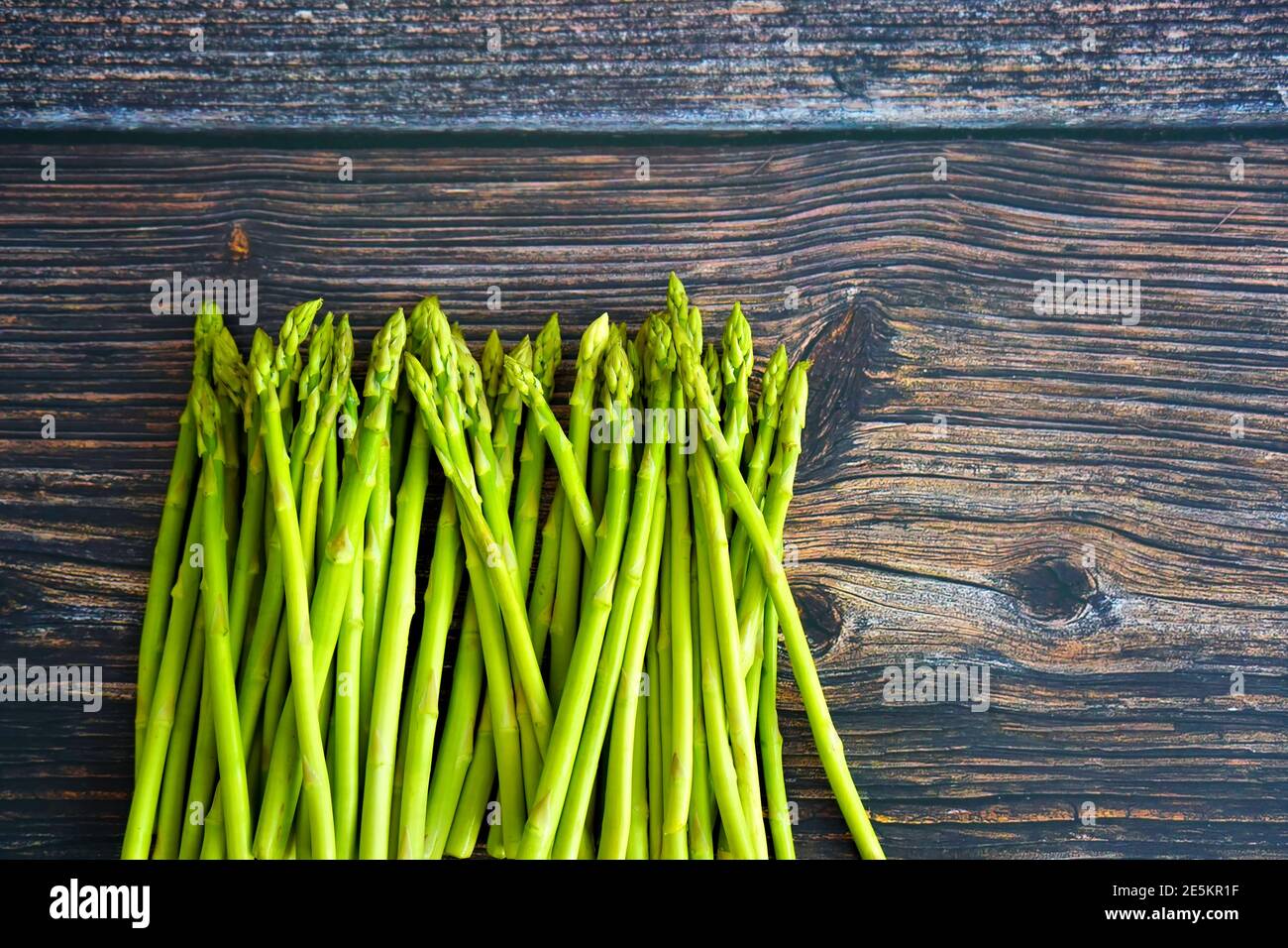 Asparagi verdi su un tavolo rustico in legno. Foto Stock