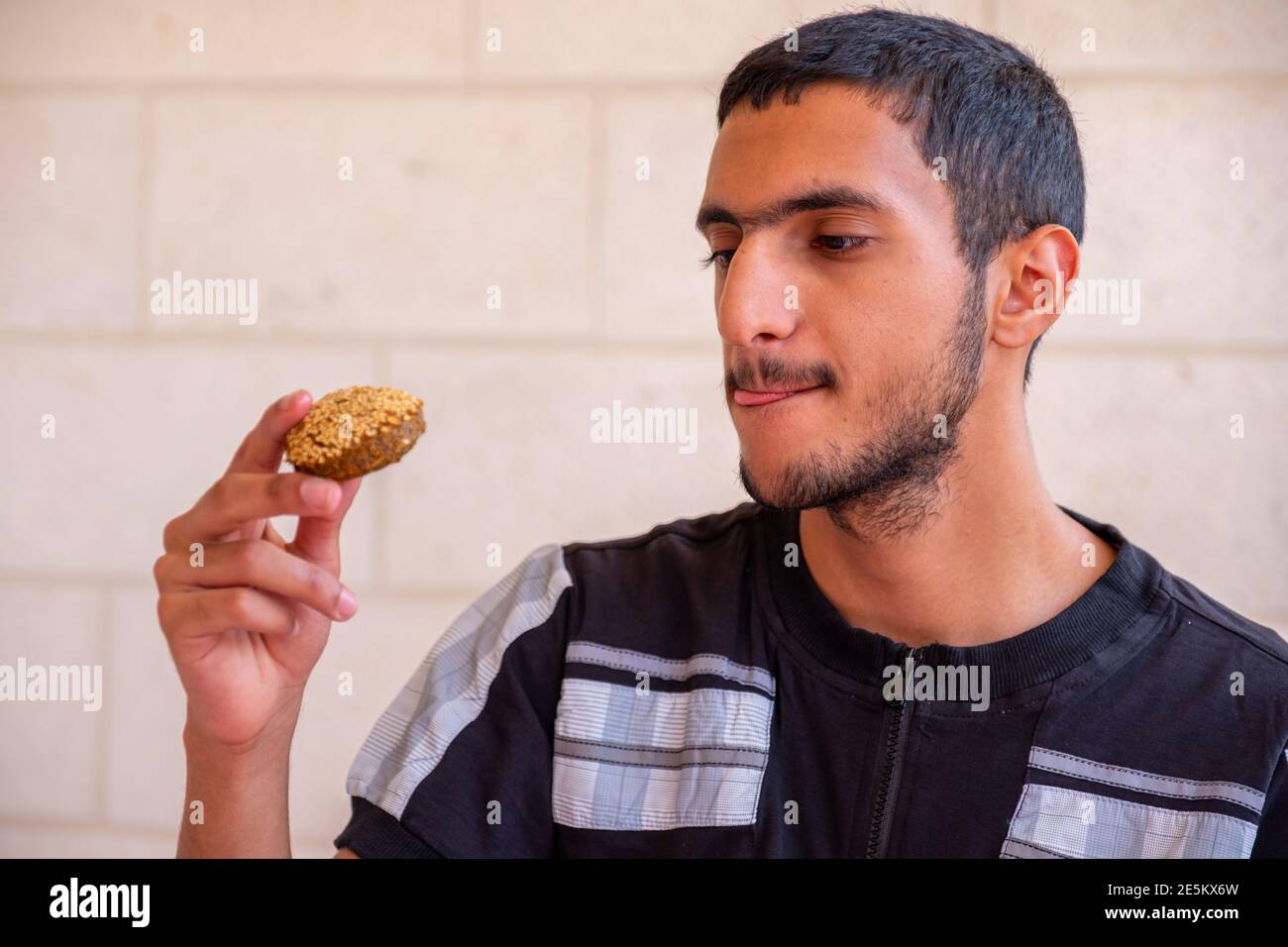 L'uomo musulmano sta mangiando falafel e godendo il suo tempo Foto Stock