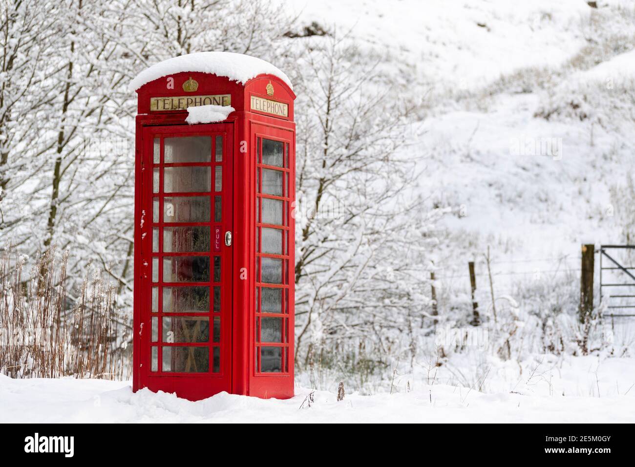 Kirkby Stephen, Cumbria, Regno Unito, 9 gennaio 2020. Una scatola telefonica rossa spicca tra la neve in una comunità rurale isolata, Outhgill, a Mallerstang vicino Foto Stock