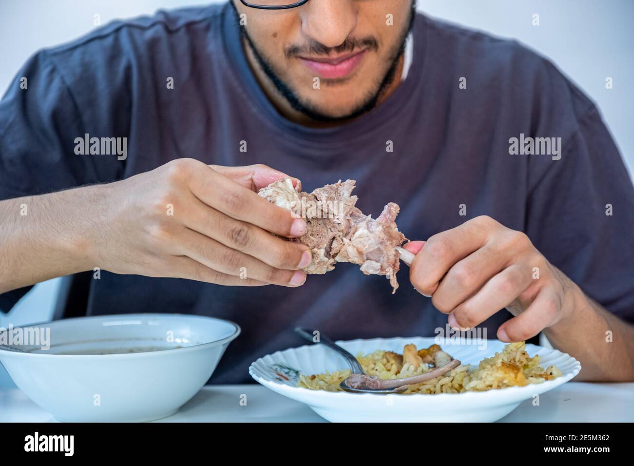 Ragazzo musulmano che si gode il suo pasto Foto Stock